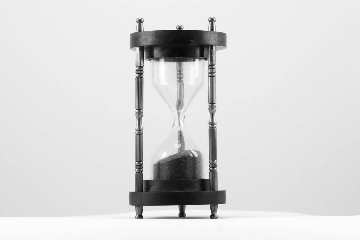 Un reloj de arena con arena rosa
