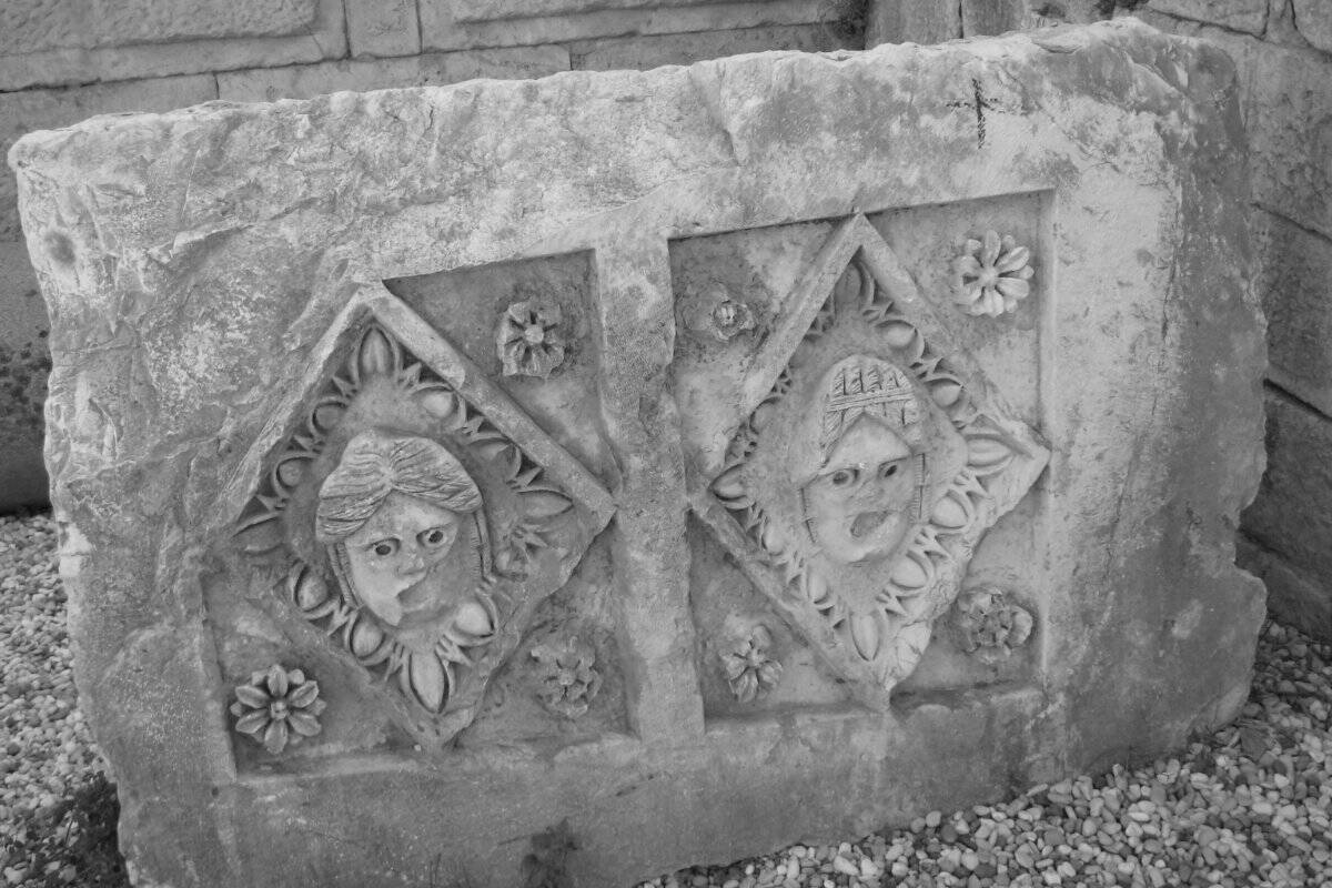Relieve antiguo de piedra con dos caras talladas, en Myra (Turquía)